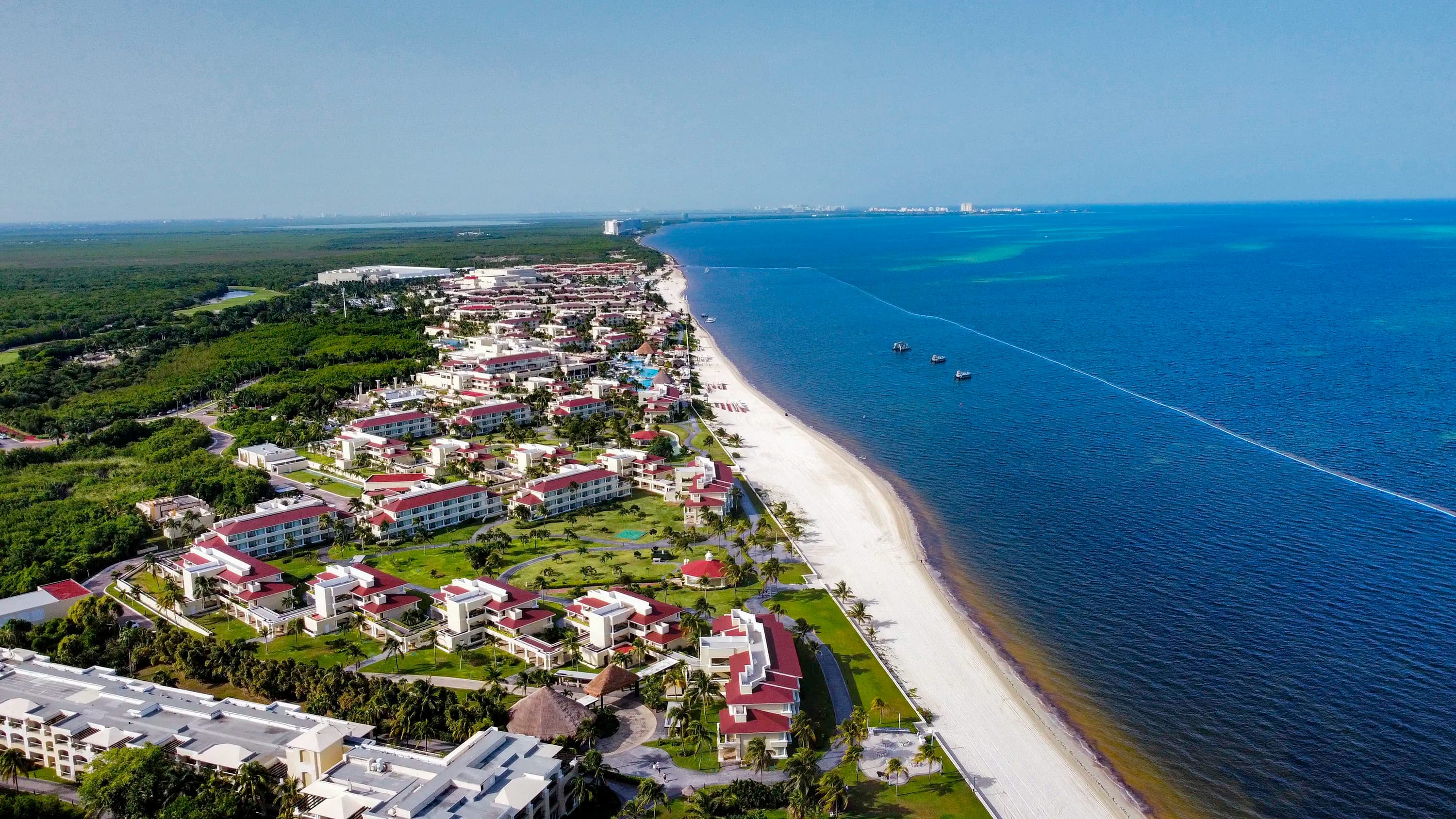 Aerial frame of a resort beach by MO Photos — sand, surf, structure in clean composition.